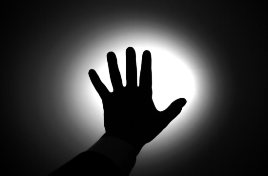 black and picture of hand against light