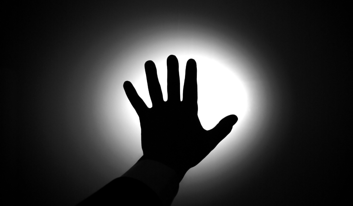 black and picture of hand against light