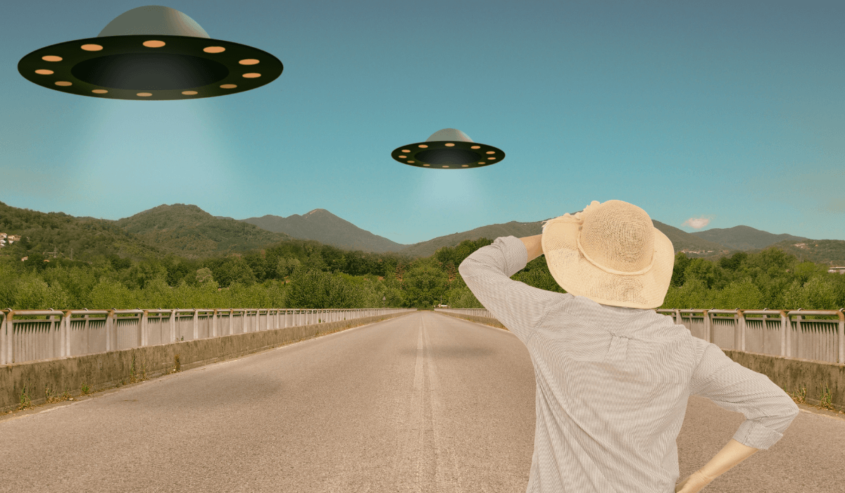 man wearing a hat facing UFO