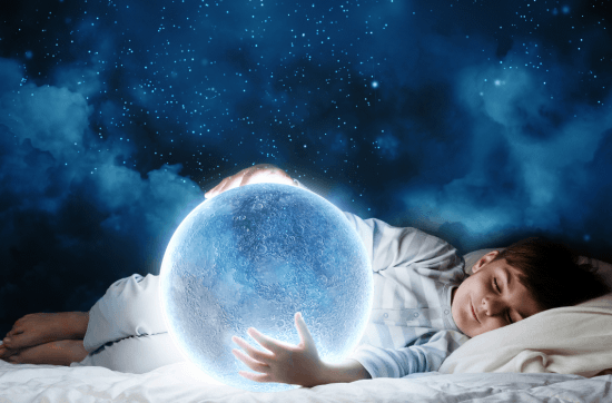 child sleeping holding a crystal ball with dream in it