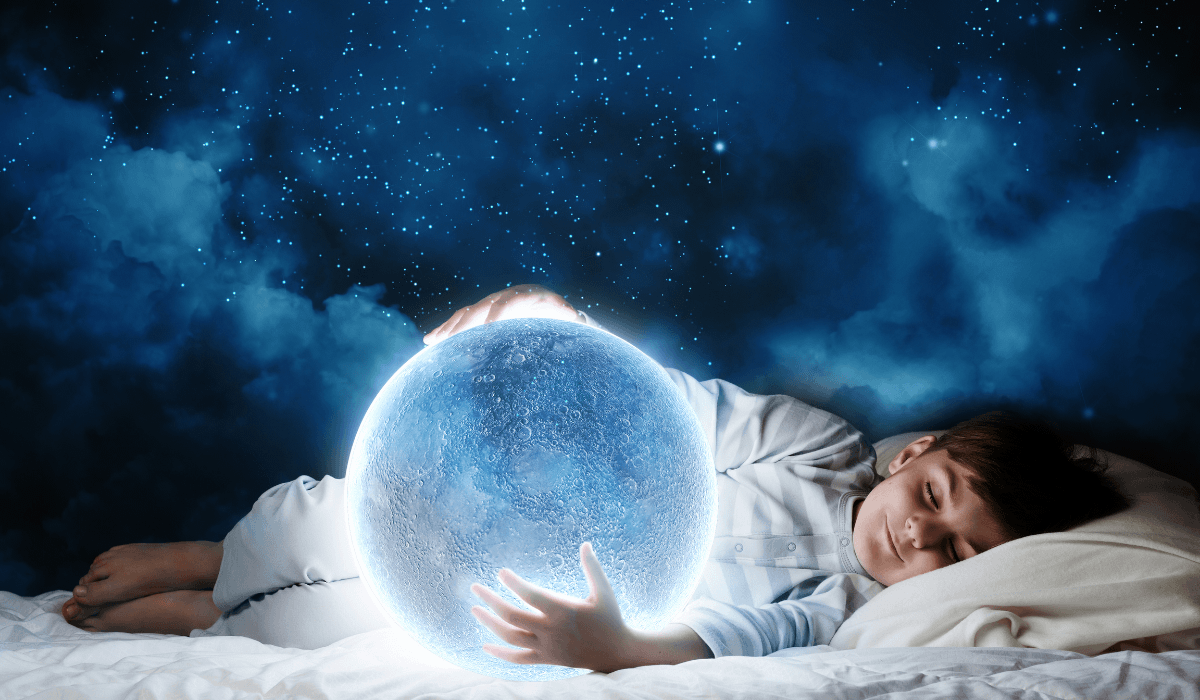 child sleeping holding a crystal ball with dream in it