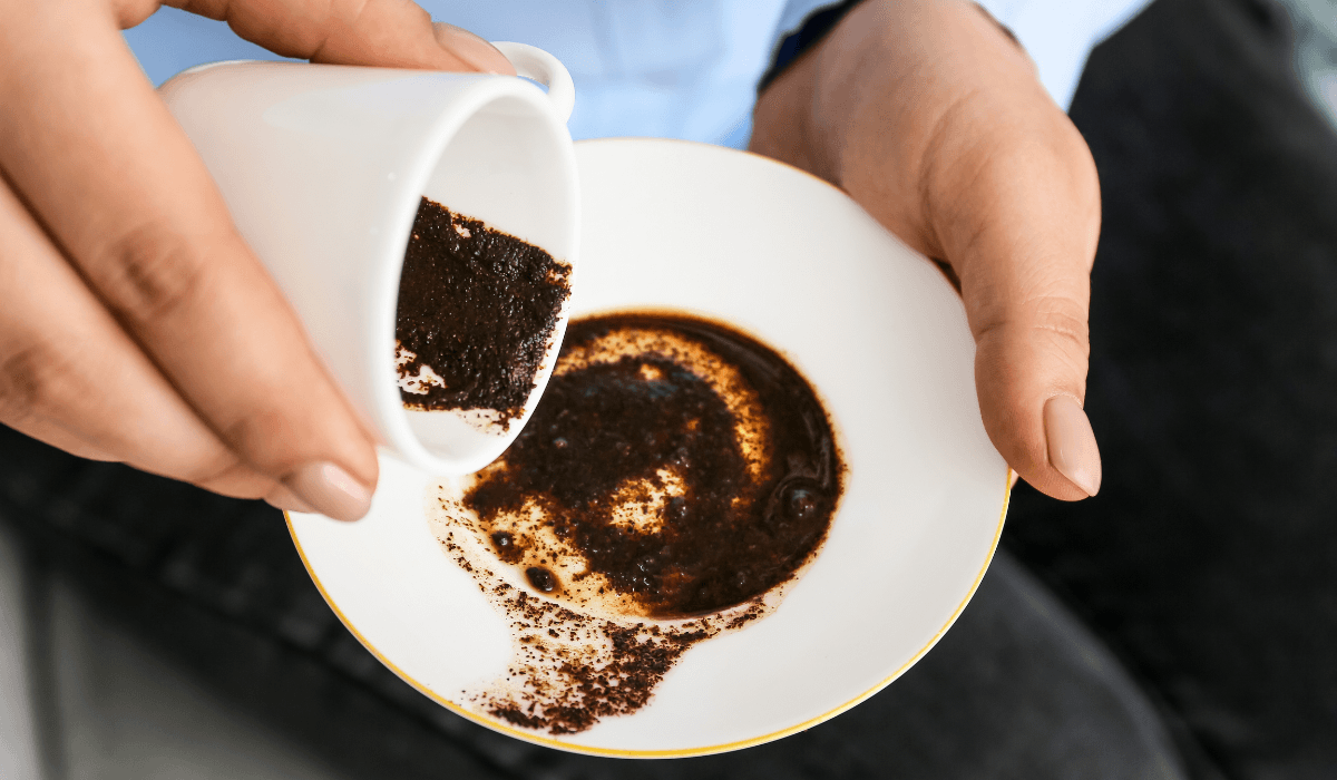 hand holding turned over yellow Turkish coffee cup