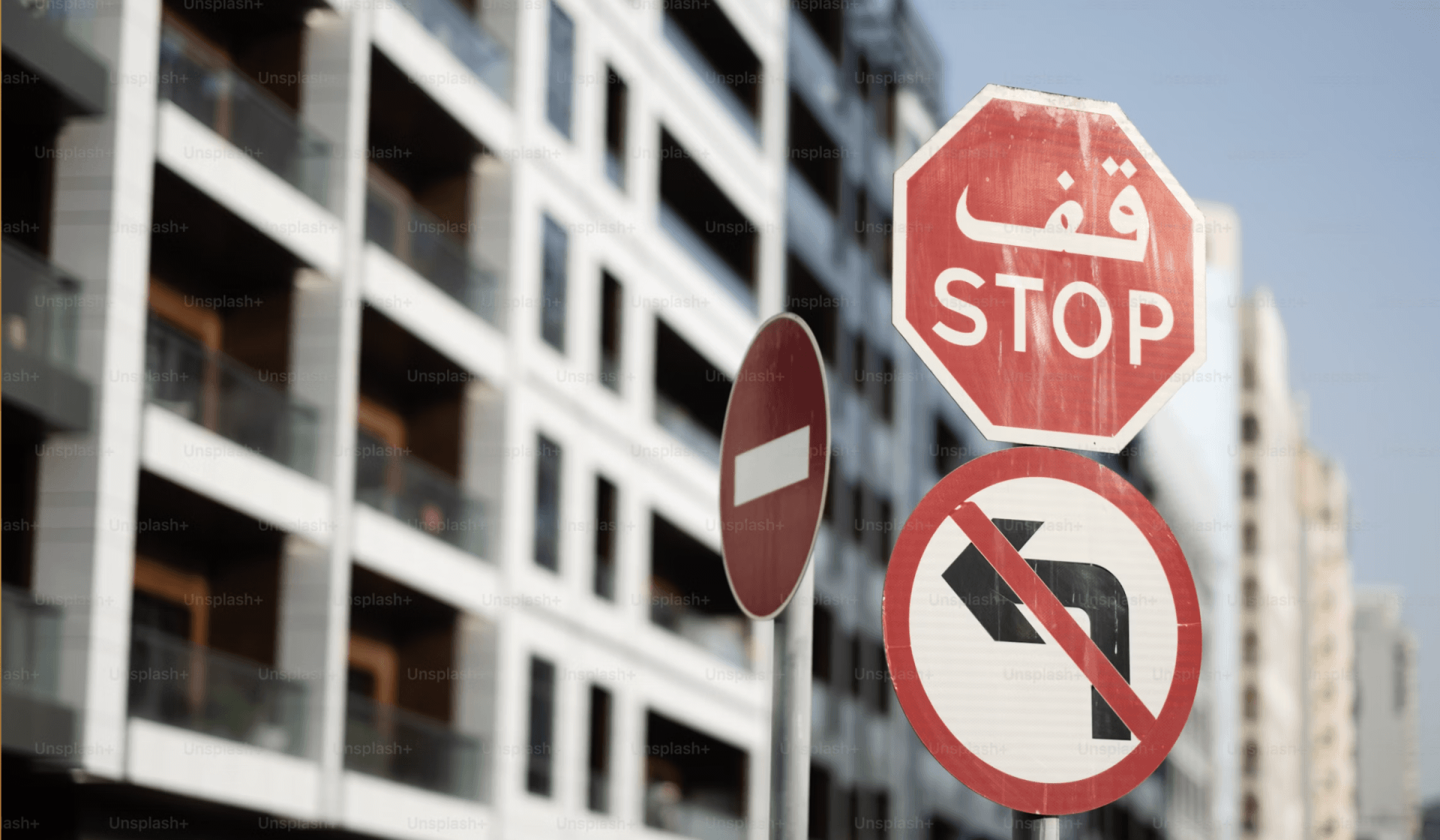 apartment block with stop sign in arabic in the foreground