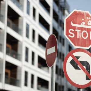 apartment block with stop sign in arabic in the foreground