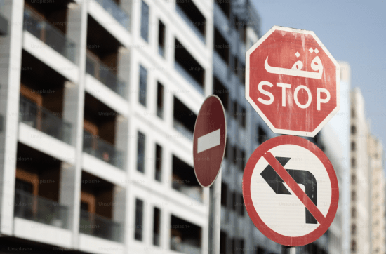 apartment block with stop sign in arabic in the foreground