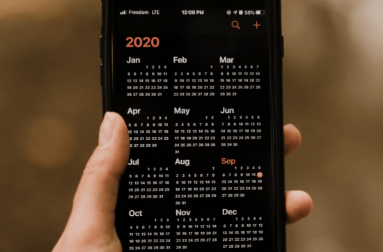 hand holding mobile calendar of 2020