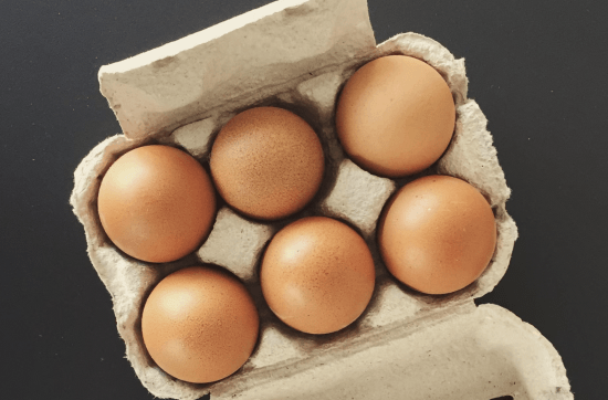 top view of six brown eggs in a package