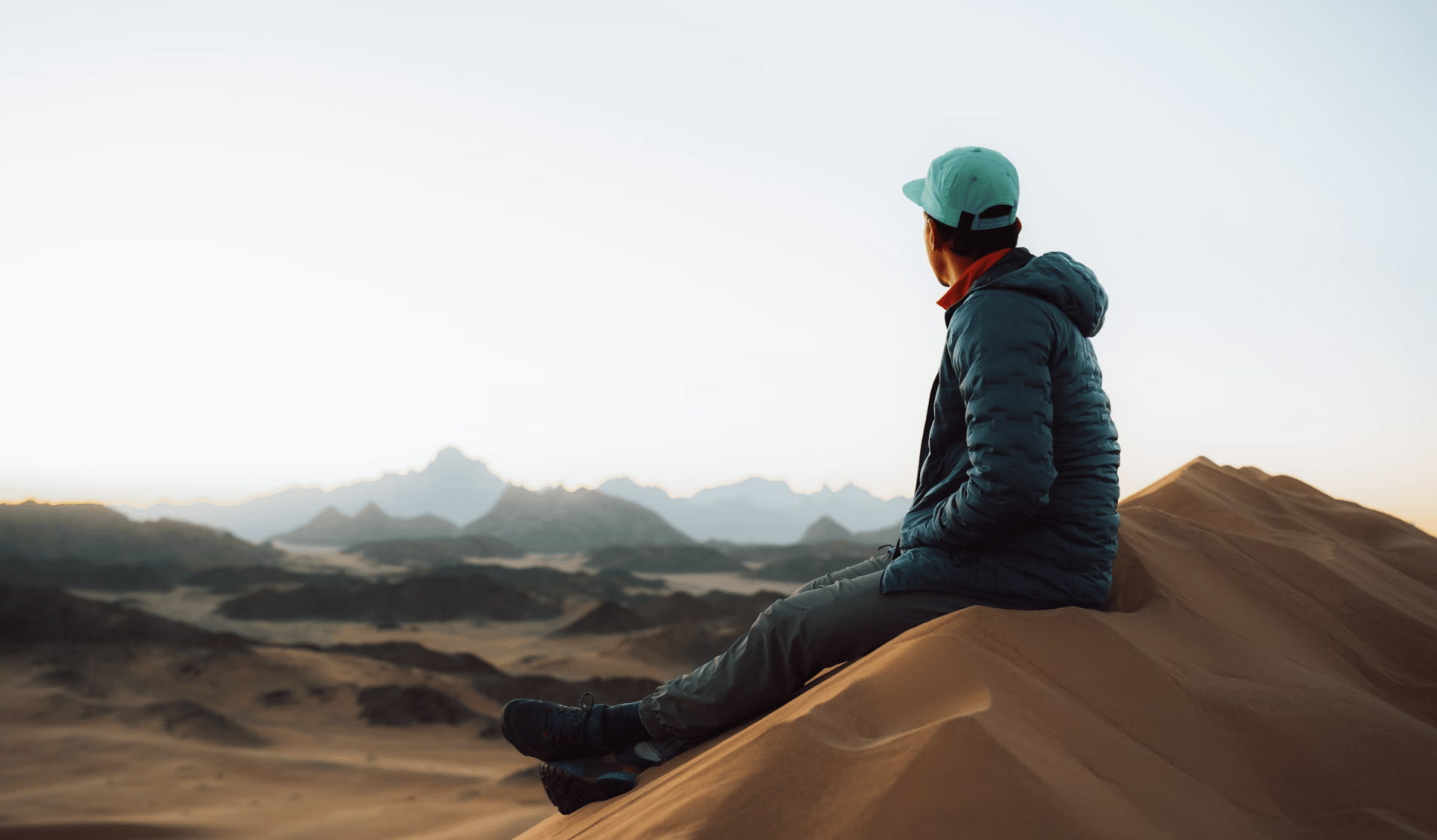 man sitting at the top of a mountain