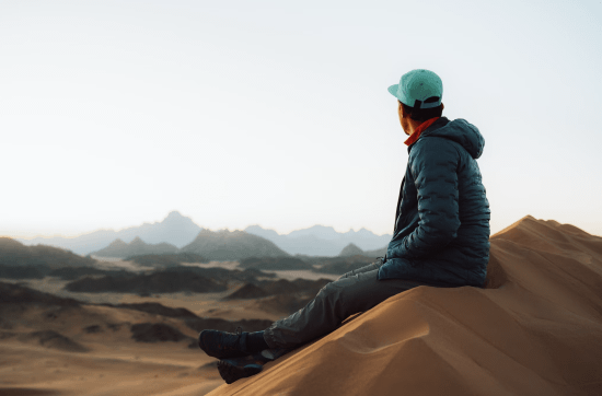 man sitting at the top of a mountain