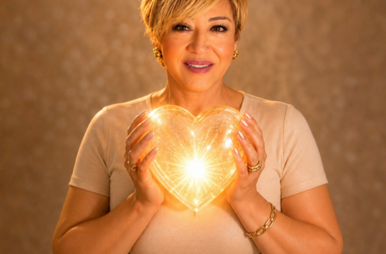 Life mentor Sahar Huneidi Palmer holding a yelloow crystal heart on the cover of her The Love Webinar