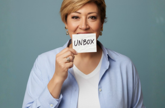 Life mentor Sahar Huneidi Palmer holding a card with the word UNBOX on it