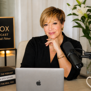 Sahar Huneidi Palmer recording Unbox The Podcast with microphone and laptop, focused on alignment and clarity