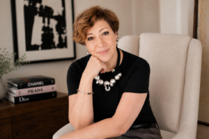 Intuitive Life Mentor in Dubai, Sahar Huneidi Palmer, in black top sitting on beige armchair